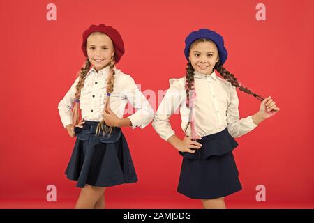 Les enfants belles filles de long cheveux tressés. Style de fantaisie. Peu de filles avec des tresses, des prêts pour l'école. Concept de la mode de l'école. L'École de l'amitié. Sur la même vague. Usure uniforme de l'école formelle écolières. Banque D'Images