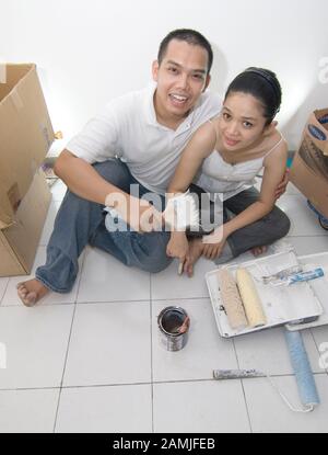 Un couple s'asseoir dans leur chambre après rénovation. Banque D'Images