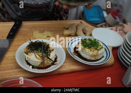 Femme cuisine De l'agedashi tofu Maison avec sauce soja Banque D'Images