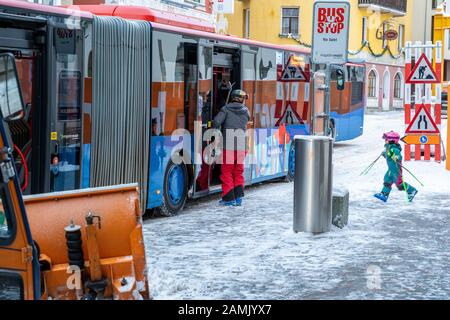 Saint-Mortiz, Suisse - 22 décembre 2019 - un jeune garçon et son père prennent un bus public pour aller skier à Saint-Mortiz, Suisse, pendant une journée de neige froide Banque D'Images