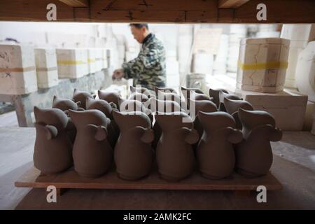 (200114) -- JINGDEZHEN, 14 janvier 2020 (Xinhua) -- un travailleur traite des produits en porcelaine présentant l'année chinoise du rat à Jingdezhen, dans la province du Jiangxi en Chine orientale, 8 janvier 2020. Jingdezhen, également connu sous le nom de "capitale de la Porcelaine", est célèbre pour son savoir-faire en céramique élaboré qui exige un processus de production extrêmement compliqué. Par le passé, de nombreux concepteurs de porcelaine jeunes, compétents et ambitieux pourraient créer de bons modèles, mais avaient du mal à compléter de manière indépendante la production et les ventes. Par contre, les entreprises traditionnelles qui pourraient faire de la production et des ventes manquaient Banque D'Images