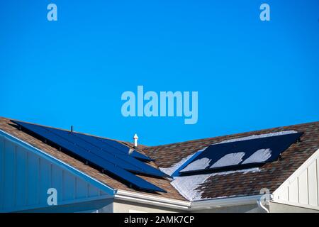 Panneaux solaires photovoltaïques et de neige sur un toit Banque D'Images
