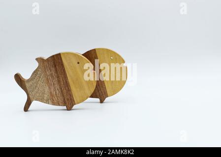Deux poissons en bois isolés sur fond blanc Banque D'Images