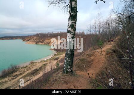 Sur la crête de la colline il y a un chemin parmi les arbres sur la Banque d'une carrière de sable. Région de Leningrad. Russie. Banque D'Images