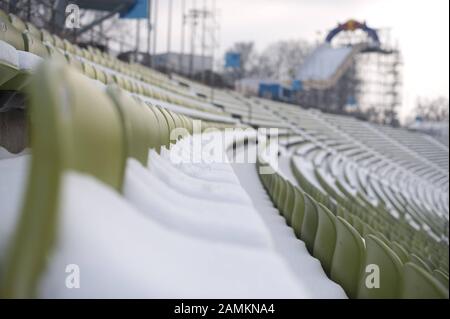 Sièges enneigés au stade olympique de Munich, en arrière-plan la patinoire du Red Bull S'Est Écrasé. [traduction automatique] Banque D'Images