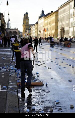 Les aides nettoyent la rue des gobelets en papier dans un stand de restauration au cours du 27ème marathon de Munich. [traduction automatique] Banque D'Images