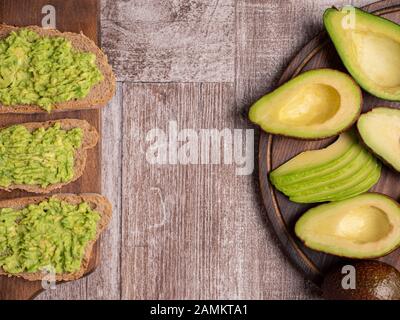 Vue sur les sandwichs frais faits avec avocat sur une planche en bois Banque D'Images