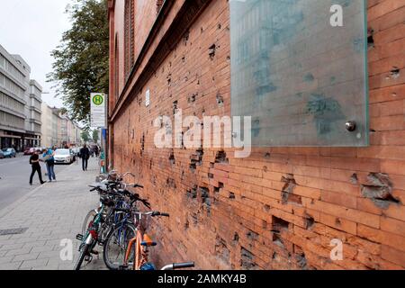 Sur le mur de la brique de Ludwig-Maximilians-Universität de Munich (LMU) à l'angle de Ludwigstraße / Schellingstraße sont des trous de balle de la seconde Guerre mondiale, plus une plaque de verre par les artistes Alexander von Weizsäcker et Beate Passow avec l'inscription "Blessures de mémoire". [traduction automatique] Banque D'Images