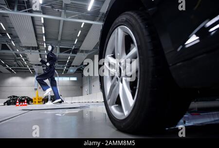 Dans le hall du centre de recherche "Charissma" de l'Université technique d'Ingolstadt, un mannequin de robot court devant une voiture de conduite autonome. [traduction automatique] Banque D'Images