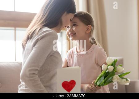 Mère et petite fille touchant les front, célébration familiale Banque D'Images