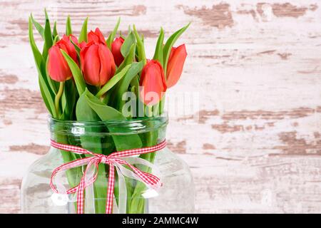 Bouquet de tulipes dans un grand vase en verre à Pâques [traduction automatique] Banque D'Images