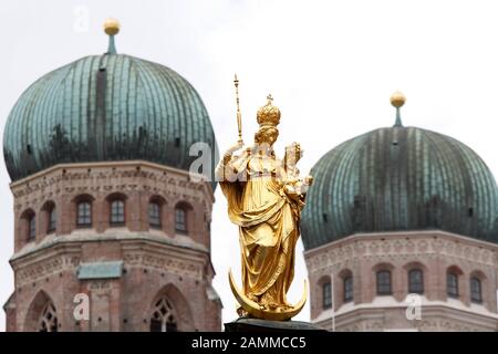 La statue de la Vierge Marie sur la Marienplatz de Munich avec les tours de la Frauenkirche en arrière-plan. [traduction automatique] Banque D'Images