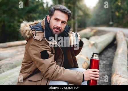 Portrait de l'homme de belle consommation de thé chaud dans la forêt d'automne Banque D'Images