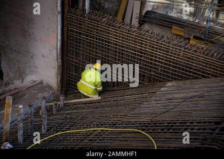 Un ouvrier se coule dans la fosse d'excavation du site de construction à la Sendlinger Tor. [traduction automatique] Banque D'Images