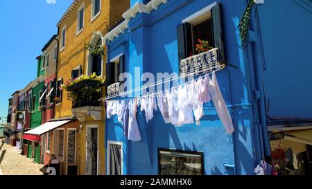 Séchage de linge blanc sur la façade bleue de la maison, rue de l'île de Burano, vie en Italie Banque D'Images