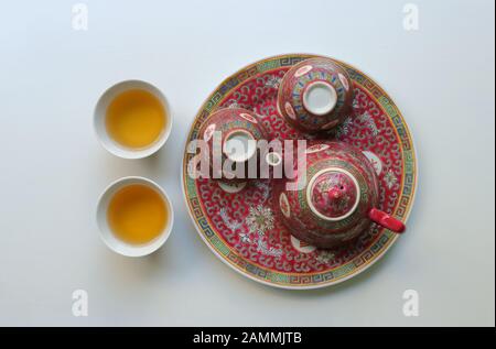 Thé en porcelaine de Chine d'époque, théière et deux tasses vides sur soucoupe, les autres remplies de thé, les caractères chinois signifient longévité Banque D'Images