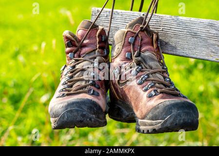 Bottes de randonnée suspendues sur un banc en bois au repos [traduction automatique] Banque D'Images