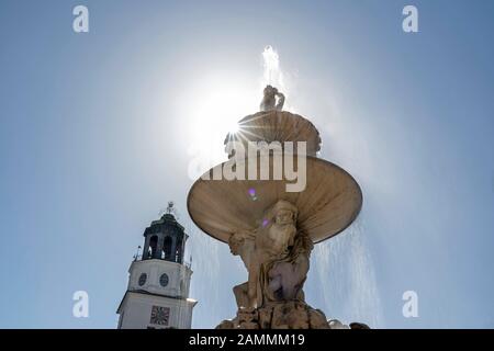 Le soleil derrière la Residenzbrunnen sur la Residenzplatz en face de la cathédrale de Salzbourg [traduction automatique] Banque D'Images