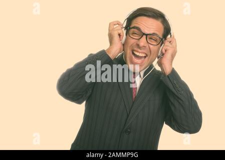 Gros plan sur un jeune homme d'affaires persan attentif souriant tout en écoutant de la musique Banque D'Images
