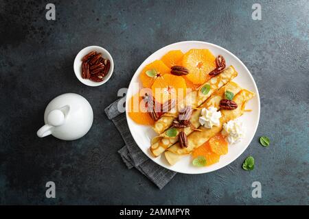 Crêpes, crêpes fines avec tranches de mandarine fraîche, noix de pécan, sirop et crème fouettée Banque D'Images