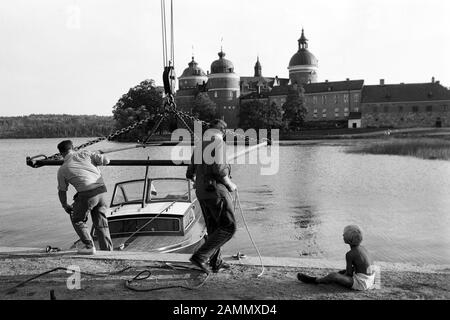 Seeblick auf Schloss Gripsholm am See Mälaren mit Boot und Männern (Kind) am Anlegeplatz, bei Stockholm, Schweden, 1969. Vue sur le lac du château de Gripsholm sur le lac Mälaren avec bateau et homme (enfant) à amarrer, près de Stockholm, Suède, 1969. Banque D'Images