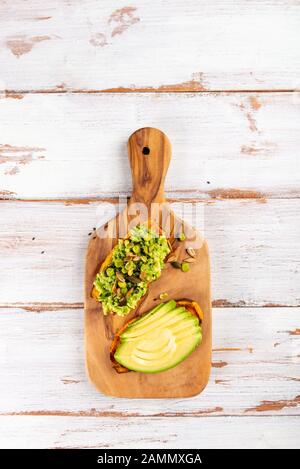 Toasts de patate douce avec avocat et graines de tournesol sur planche en bois. Concept de repas sain. Cuisine propre, cuisine végétarienne, vue sur le dessus Banque D'Images