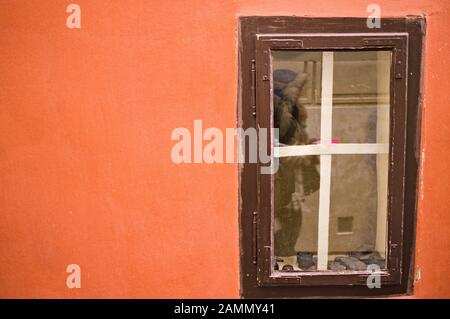 Peu de fenêtre en bois dans un mur orange (Prague, République Tchèque, Europe) Banque D'Images