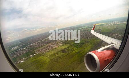 POV du passager de vol regardant par la fenêtre au sol, ciel et aile d'avion Banque D'Images