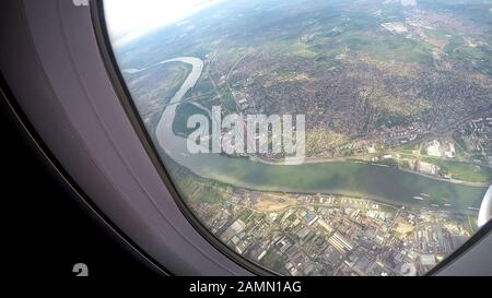 Grande ville sur les rives d'une grande rivière, belle vue de l'air à travers la fenêtre d'avion Banque D'Images