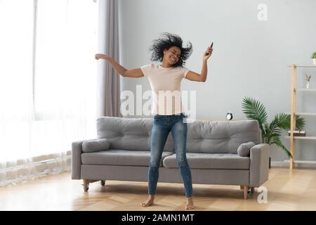 Femme africaine dansant dans le salon à la maison Banque D'Images