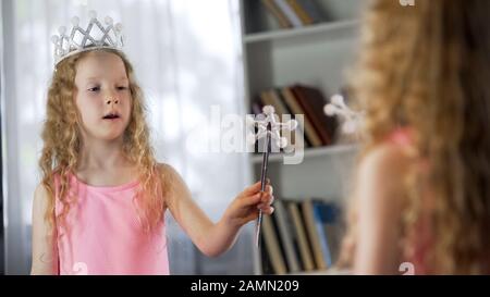 Fille à poil rouge jouant le rôle de la fée magique devant le miroir, future actrice Banque D'Images