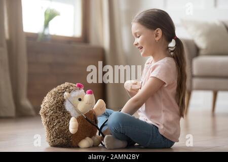 Jolie petite fille jouant médecin avec jouet et stéthoscope Banque D'Images