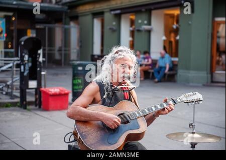 Oslo, Norvège-1 août 2013 : un musicien de rue se produit dans la rue principale de la porte Karl Johans. Cette rue est l'une des plus fréquentées de la ville, pleine de Banque D'Images