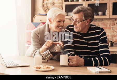 Couple senior affectueux qui s'amusent le matin ensemble dans la cuisine Banque D'Images