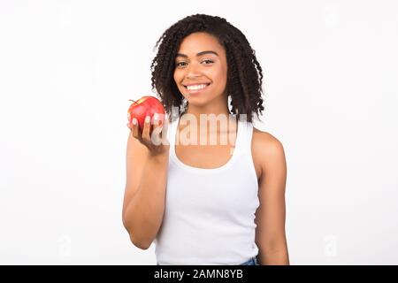 Gai afro femme tenant pomme regardant l'appareil photo Banque D'Images