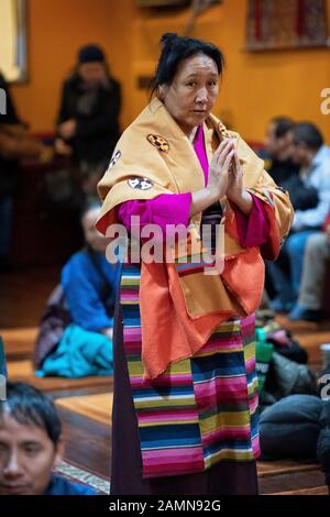 Une femme bouddhiste dévot priant et méditant comme elle entre dans un temple dans le Queens, New York City Banque D'Images