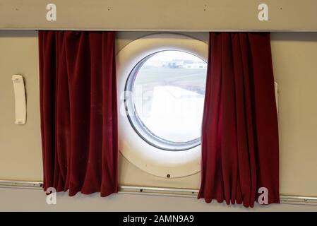 14 janvier 2020, Saxe-Anhalt, Magdeburg: Vue à travers un "hublot" à une aile du Tupolew 134 rénové L'avion de l'ancienne compagnie aérienne GDR "INTERFLUG" se tient sur le champ aérien de Magdeburg depuis 2004 et était enfin en état de désolat. Avec l'aide financière du Centre de l'emploi et du capital de l'État, les employés de l'Agence de promotion de l'emploi de Gise ont pu sauver la 'tu 134' de la désintégration finale. La machine a reçu un travail de peinture entièrement nouveau à l'extérieur et à l'intérieur. Le jet de conception russe de 1968 a été mis hors service en 1985 après un atterrissage brutal à Berlin-Schönefeld Banque D'Images