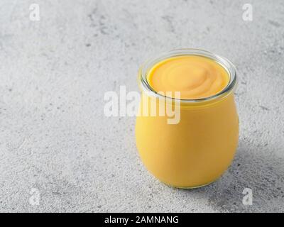 Lassi à la mangue jaune sur fond gris. Drink yaourt mangue indienne avec copie espace gauche. Banque D'Images