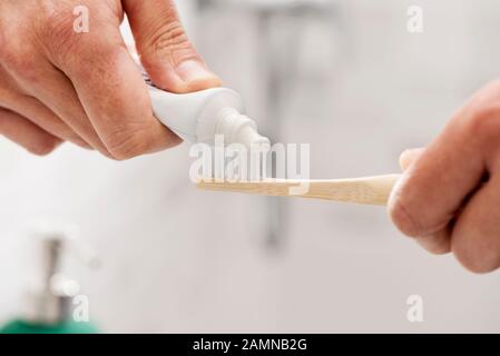 Libre d'un homme de race blanche à l'aide d'une brosse à dents dans la salle de bain en bambou Banque D'Images