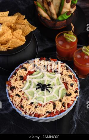 Spooky Halloween Seven Layer Taco Dip Transformer un apéritif classique en favori d'Halloween avec juste un peu d'art crème aigre et un d'olive noire Banque D'Images