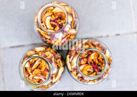 Morceaux secs déshydratés de fruits de pomme faits maison morceaux de pommes tranches dans de nombreux pots de verre plat dessus vue vers le bas Banque D'Images