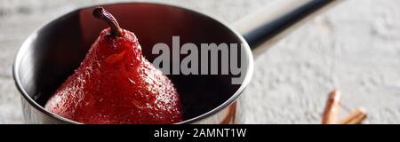 délicieuse poire en vin dans le stewpan sur la surface en béton gris, vue panoramique Banque D'Images