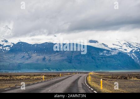 Vue sur les montagnes de l'Islande depuis l'autoroute et la falaise enneigée de montagne le jour nuageux près de Hof et du parc national de Skaftafell Banque D'Images