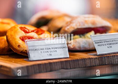 La boulangerie du restaurant affiche la proximité du pain de focacacia avec des tomates et de l'huile d'olive et un sandwich panini pour le déjeuner dans le magasin de Florence, marché italien Banque D'Images