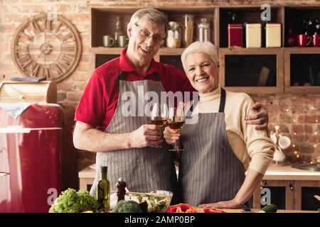 Un couple senior heureux célébrant son anniversaire dans la cuisine Banque D'Images