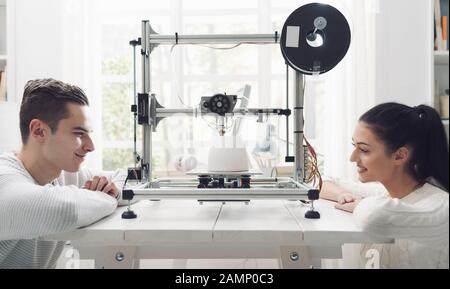 Les étudiants en ingénierie qui utilisent une imprimante innovante en trois dimensions dans le laboratoire universitaire impriment un prototype ensemble, une créativité et un concept d'éducation Banque D'Images