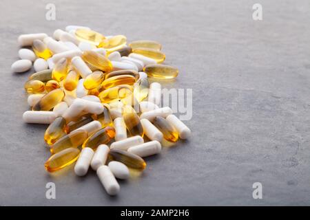 Comprimés, pilules, capsules, médicaments déversant de la bouteille blanche sur fond blanc. Sport, mode de vie sain, médecine, suppléments nutritionnels, personnes Banque D'Images