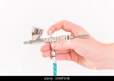 Brosse à air professionnelle dans la main de l'artiste. Isolé sur fond blanc Banque D'Images