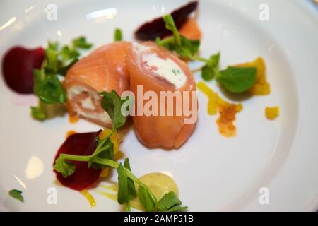 Un plat de départ de restaurant de saumon fumé roulé et de fromage à la crème. Banque D'Images