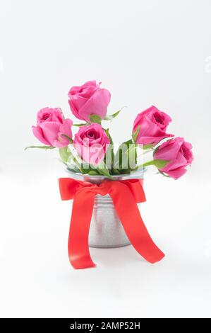 Bouquet de tulipes dans un seau en fer avec un noeud rouge Banque D'Images